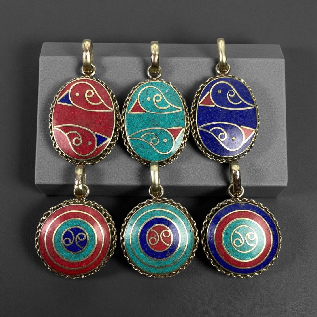 Vintage Himalayan Tribal Pendants, Lot of 6, c. 20th Century, 3-4 cm, 72DA: These vintage Himalayan pendants capture the spirit and artistry of traditional jewelry from the highlands of Tibet and Nepal. Crafted with vibrant inlay work and detailed metal framing, they exemplif