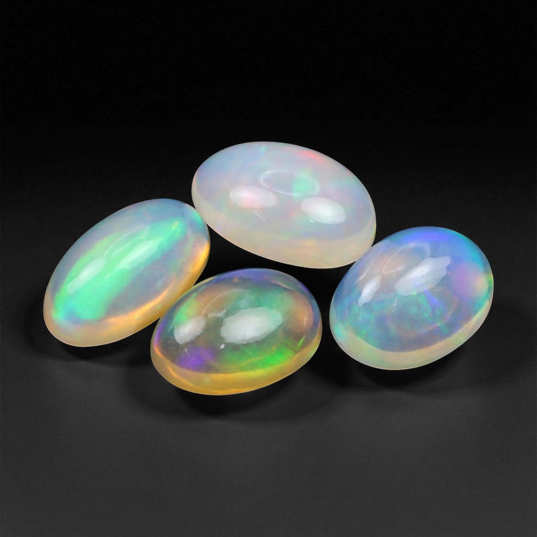 10.16 Carats Neon Play-of-Color Opal Selection - Natural Ethiopian Cabochons - 11 to 13 mm, 48XE: This luminous selection of opals radiates a dynamic spectrum of neon hues, with flashes of electric green, vivid orange, and spectral blue dancing across each dome. Their translucent base allows the i