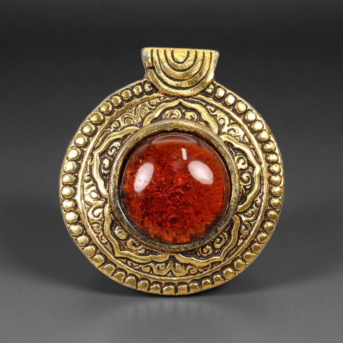 Vintage Himalayan Tribal Amber Resin and Brass Mandala Pendant, 20th Century, 7cm, 35XD: This striking round pendant embodies the refined spiritual symbolism and ornate craftsmanship of Himalayan tribal jewelry. At its heart lies a polished amber resin cabochon, glowing in rich tones of g
