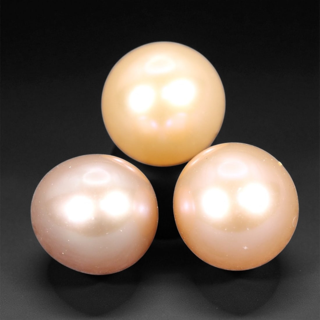 6.00 mm Warm Peach Freshwater Pearl Trio - Natural Round Pearls, 45XF: This delicate trio of freshwater pearls showcases a glowing palette of soft peach, warm cream, and gentle blush, brought to life by a smooth surface and refined luster. Each pearl reflects light with 
