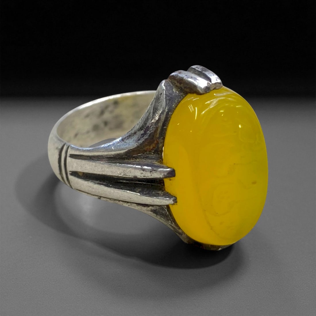 Antique Persian Yellow Chalcedony Silver Ring, c. Early 20th Century, Ring Size 10.5, 9g, 43CC: This refined antique silver ring exemplifies the enduring Persian tradition of integrating color and symbolism into everyday adornment. The oval yellow chalcedony, polished to a honey-like translucenc