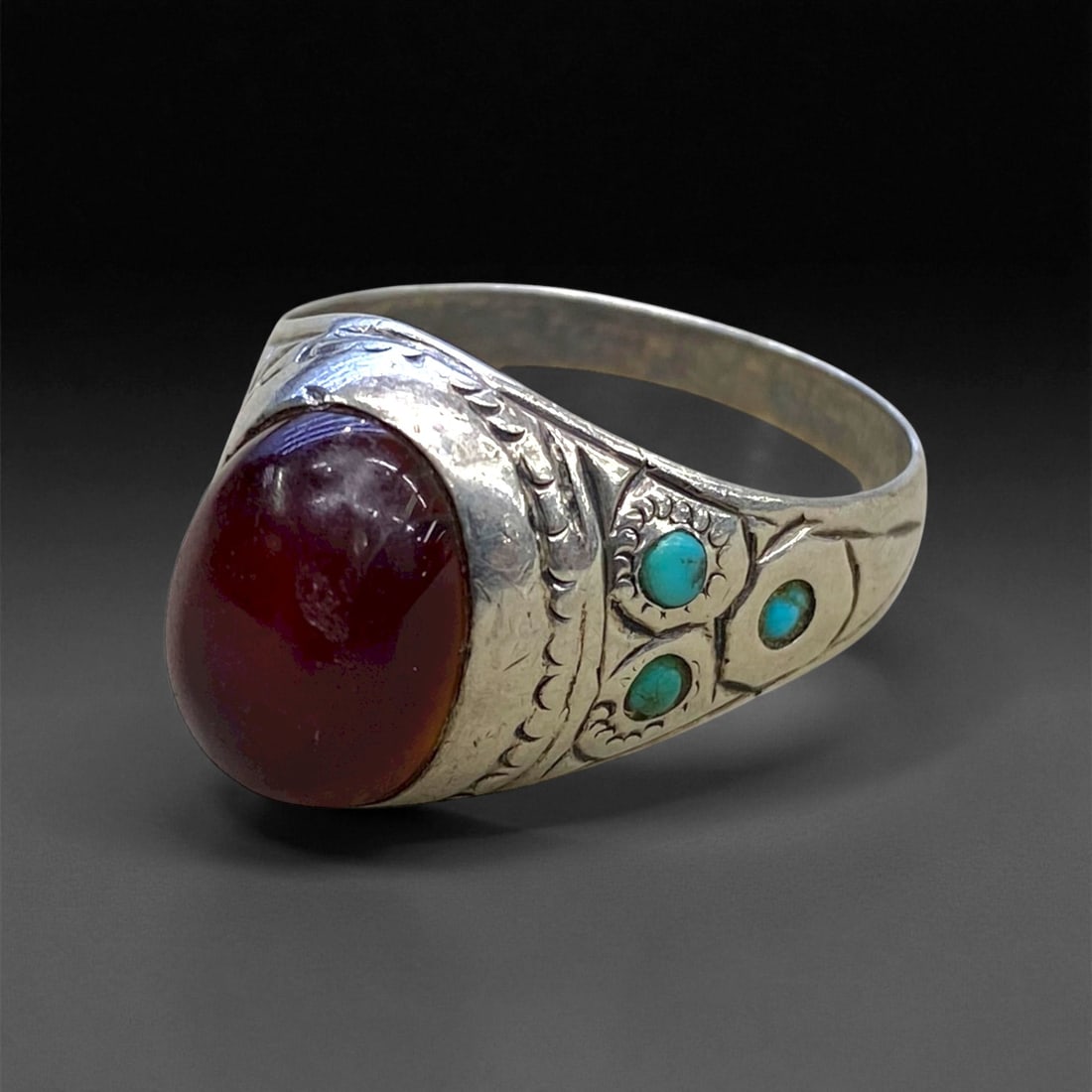 A Persian Carnelian and Turquoise Inlay Silver Ring, c. Early 20th Century, Ring Size 9, 4.6g, 47CC: This delicate yet expressive A Persian silver ring captures the elegance of early 20th-century silversmithing from Iran's artistic centers such as Isfahan and Shiraz. The centerpiece, a deep red carne