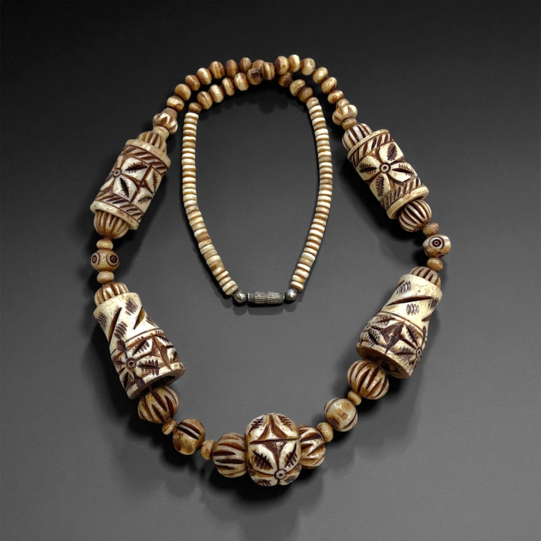 Vintage Hand-Carved Bone Bead Necklace with Geometric Floral Motifs, Mid-20th Century, 84g, 53BB: This elegant vintage necklace, crafted in the mid-20th century, features an impressive arrangement of hand-carved bone beads adorned with geometric and floral motifs. The design showcases five large c