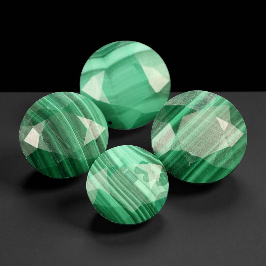 45.15 Carats Faceted Round Malachite Parcel - Natural 4-Piece Lot, 1.2 to 1.4 cm, 43XE: This distinctive parcel of four faceted malachite rounds showcases an uncommon presentation of a traditionally cabochon-cut material. Each gem features vibrant striations of mint and forest green arra