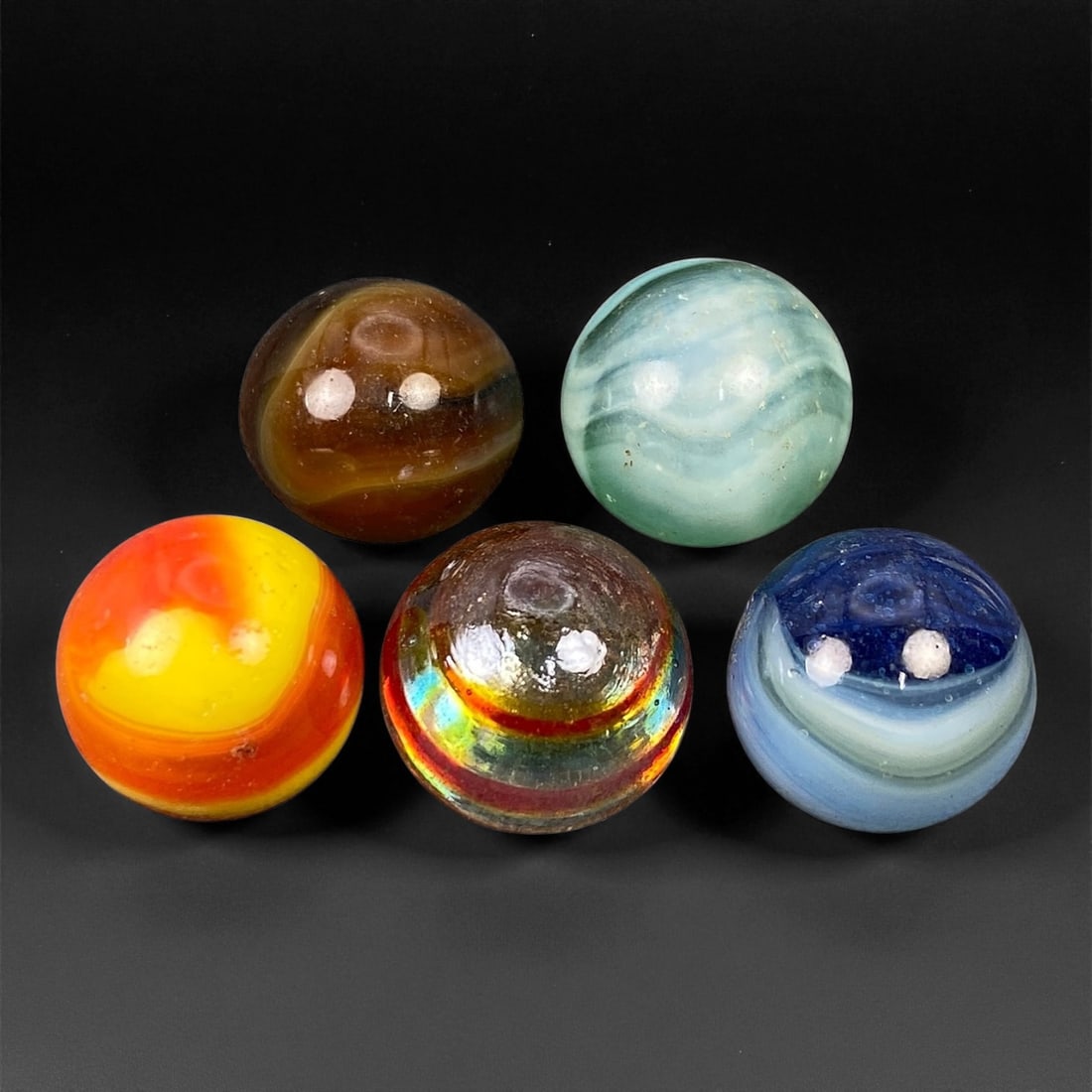 Vintage Glass Marbles Lot, Mid-20th Century, 1.5-1.6cm, 22EK: This charming lot of vintage glass marbles, dating from the mid-20th century, reflects the artistry and playfulness of early handmade and molded glass craftsmanship. These marbles were produced during