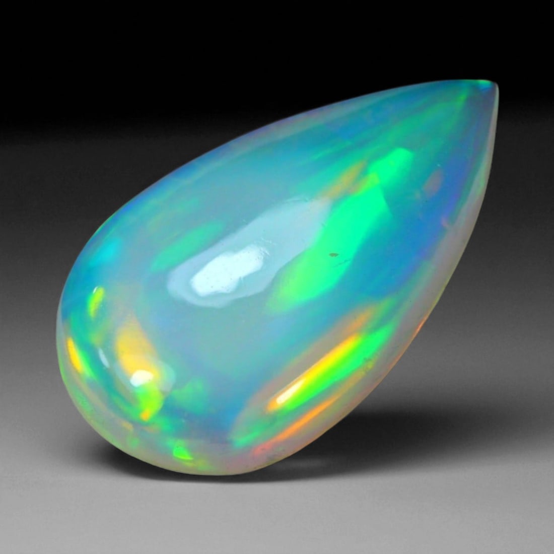5.00 Carats Fiery Play-of-Color Welo Opal Oval Cabochon - Natural Ethiopian Stone, 69WE: This mesmerizing Welo opal radiates a luminous play-of-color that dances across its translucent body in vivid flashes of red, orange, green, and violet 19x11.3x4.9mm. The gem's opalescent base glows w