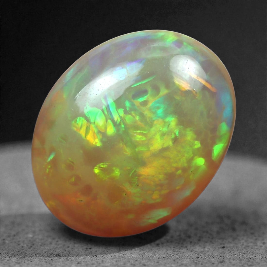 4.02 Carats Neon Flame Opal Cabochon - Natural Ethiopian Welo Stone, 83XB: This striking Ethiopian Welo opal flashes with intense green, golden yellow, and orange fire, creating a vivid play-of-color that bursts through its translucent body. The rounded oval shape (14.7 x 11