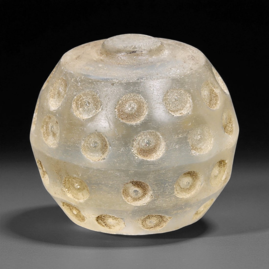 Ancient Medieval Coptic Egyptian Raised Dot Glass Chess Piece, c. 10th-12th Century CE, 3.2cm, 56ER: Carved from translucent glass with a faint honeyed tone, this domed chess piece dates to the Coptic Egyptian period of the Medieval era, circa 10th-12th century CE. The piece exhibits a carefully exec