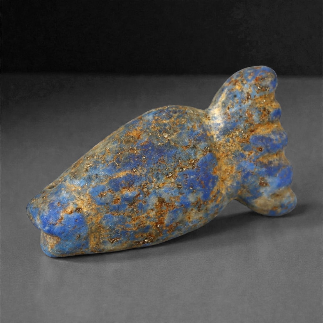 Ancient Egyptian New Kingdom Lapis Lazuli Fish Amulet, c. 1550-1069 BCE, 3cm, 47A: This beautiful lapis lazuli fish amulet originates from Egypt's New Kingdom (c. 1550-1069 BCE), a flourishing era of spiritual symbolism and refined craftsmanship. The fish, a sacred creature in Egypt