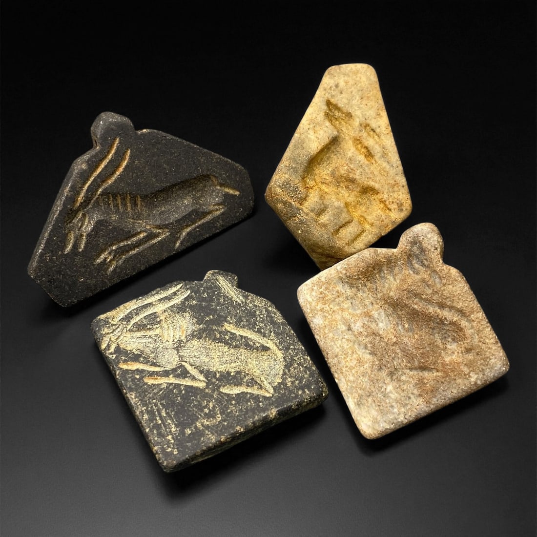 Ancient Neo-Assyrian Steatite Amulet Group, c. 8th-7th Century BCE, 3.5-4.2cm, 78EK: This rare assemblage of four carved steatite amulets originates from the Neo-Assyrian period, a pinnacle of Mesopotamian artistry renowned for its intricate symbolism and protective talismans. Each pi
