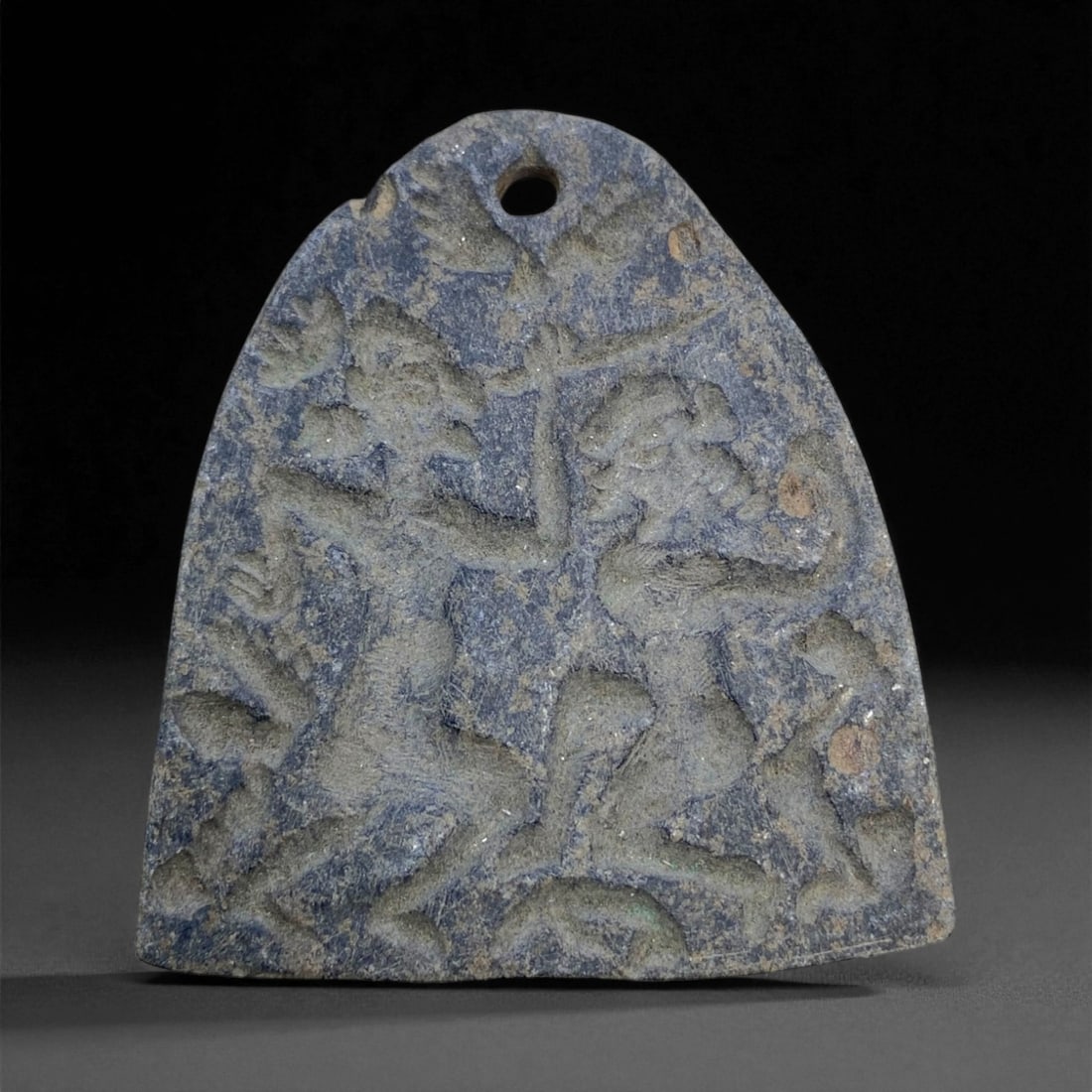 Ancient Elamite Warrior Combat Scene Schist Amulet, c. 2nd Millennium BCE, 7cm, 66g, 54AA: This formidable amulet, carved from dense dark schist, originates from the Elamite civilization of southwestern Iran and dates to the 2nd millennium BCE. Its relief scene, depicting two dynamic, nude