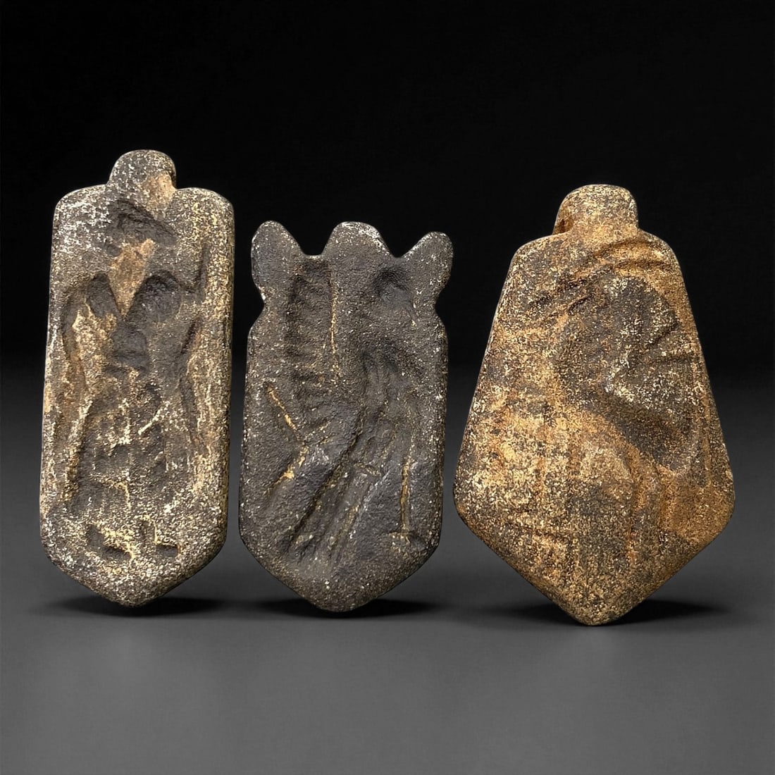 Ancient Neo-Assyrian Steatite Amulet Group, c. 8th-7th Century BCE, 4-4.8cm, 72EK: This rare assemblage of three carved steatite amulets originates from the Neo-Assyrian period, a pinnacle of Mesopotamian artistry renowned for its intricate symbolism and protective talismans. Each p