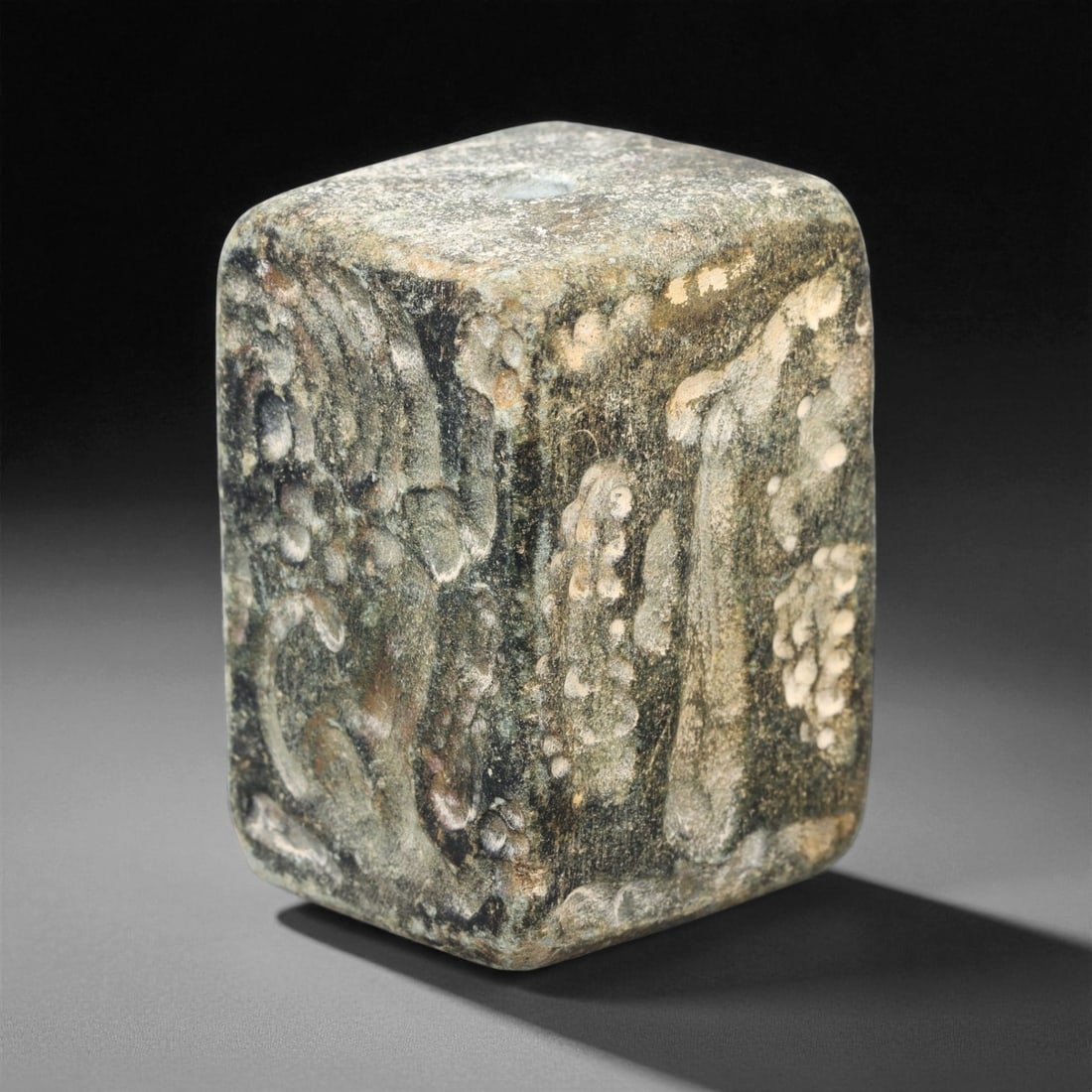 Ancient Akkadian Fossilized Stone Amulet, c. 24th-22nd Century BCE, 4.2cm, 63ES: This rectangular fossilized stone amulet from the Akkadian period embodies the fusion of spiritual belief and refined craftsmanship that defined early Mesopotamian culture. Carefully shaped and pierce