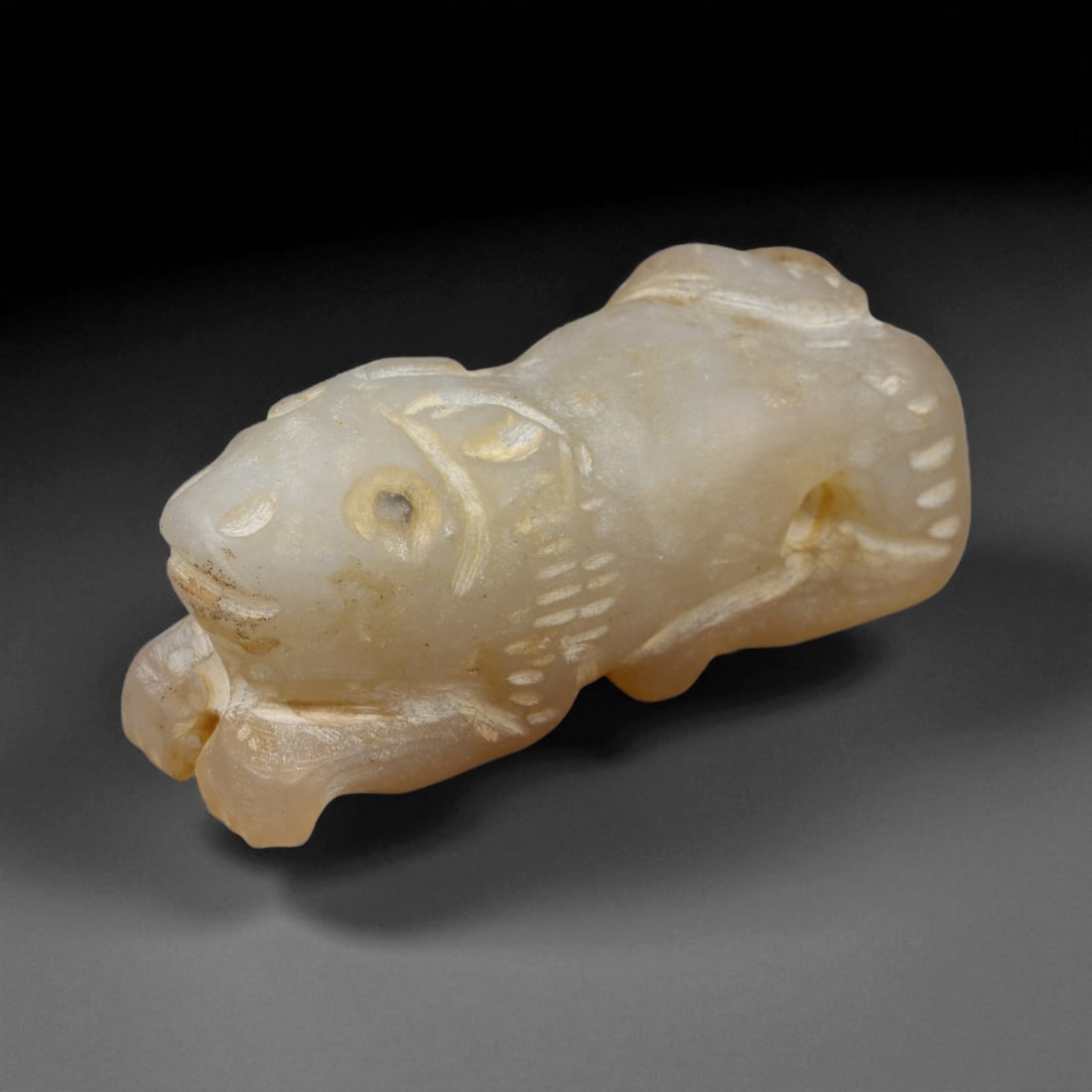 Ancient Bactrian Feline Amulet in Alabaster Stone, c. 2200-1800 BCE, 5 cm, 90BF: This compact amulet, carved in the form of a crouching feline, originates from the ancient Bactrian region-modern northern Afghanistan and southern Central Asia-during the Bronze Age. Crafted from fin