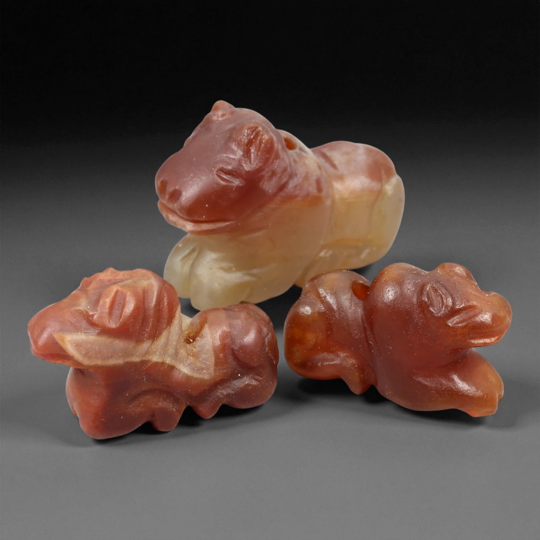Ancient Coptic Carnelian Zoomorphic Amulets, c. 4th-7th Century CE, 2.2-2.6cm, 20EN: These finely carved Coptic amulets, dating to Late Antiquity (4th-7th century CE), are fashioned from warm carnelian and agate in tones of amber, red, and honey. Each figure represents a stylized recl