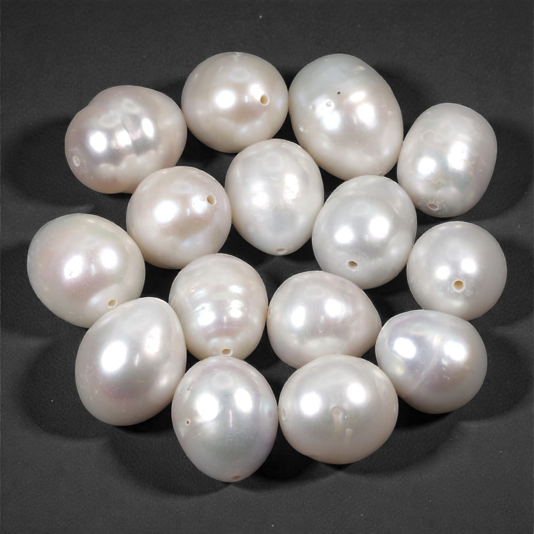 A Group of Keshi Pearls, 20th Century, 1.1-1.3cm, 84LH: Comprising a group of irregular, baroque-form keshi pearls of white to softly iridescent tone, each drilled laterally for stringing. The pearls display the naturally uneven surfaces and organic outlin
