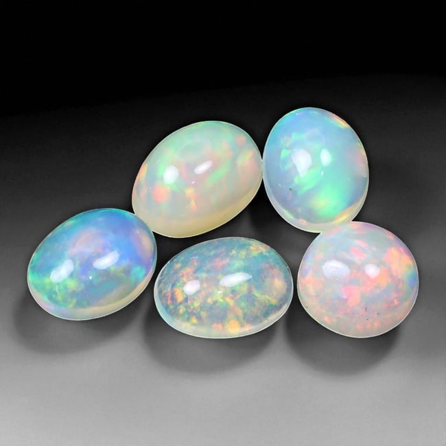 6.35 Carats Multi-Color Welo Opal Lot - Natural Ethiopian Stones, 81WD: This radiant group of Welo opals displays a mesmerizing interplay of color that dances across the surface with every shift of light. Electric flashes of green, orange, and red ripple through a translu