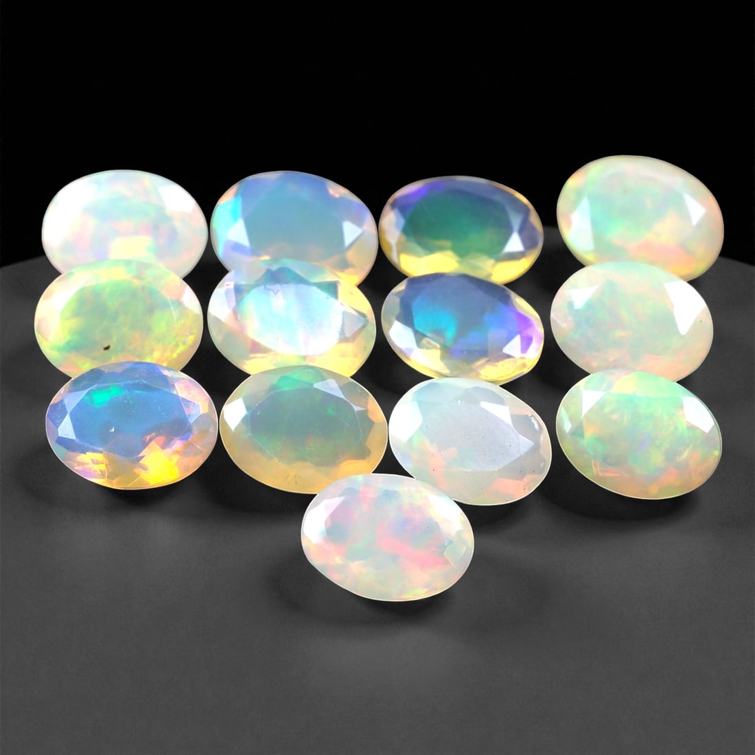9.50 Carats Oval Cabochon Opal Parcel - Natural Welo Ethiopian Stones, 30XC: This mesmerizing parcel features 8x6 mm oval-cut opals, each glowing with exceptional play-of-color across a luminous, translucent body. Flashes of electric green, oceanic blue, and golden orange shif
