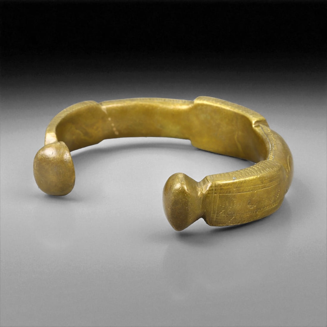 A West African Royal Manilla Currency Bracelet Symbolic Bronze Form, 19th Century, 8cm, 165g, 27Q: This powerful A currency bracelet, known as a manilla, originates from West Africa and dates to the 19th century. Heavy, closed-ended forms like this were often used not only in trade but also as symb