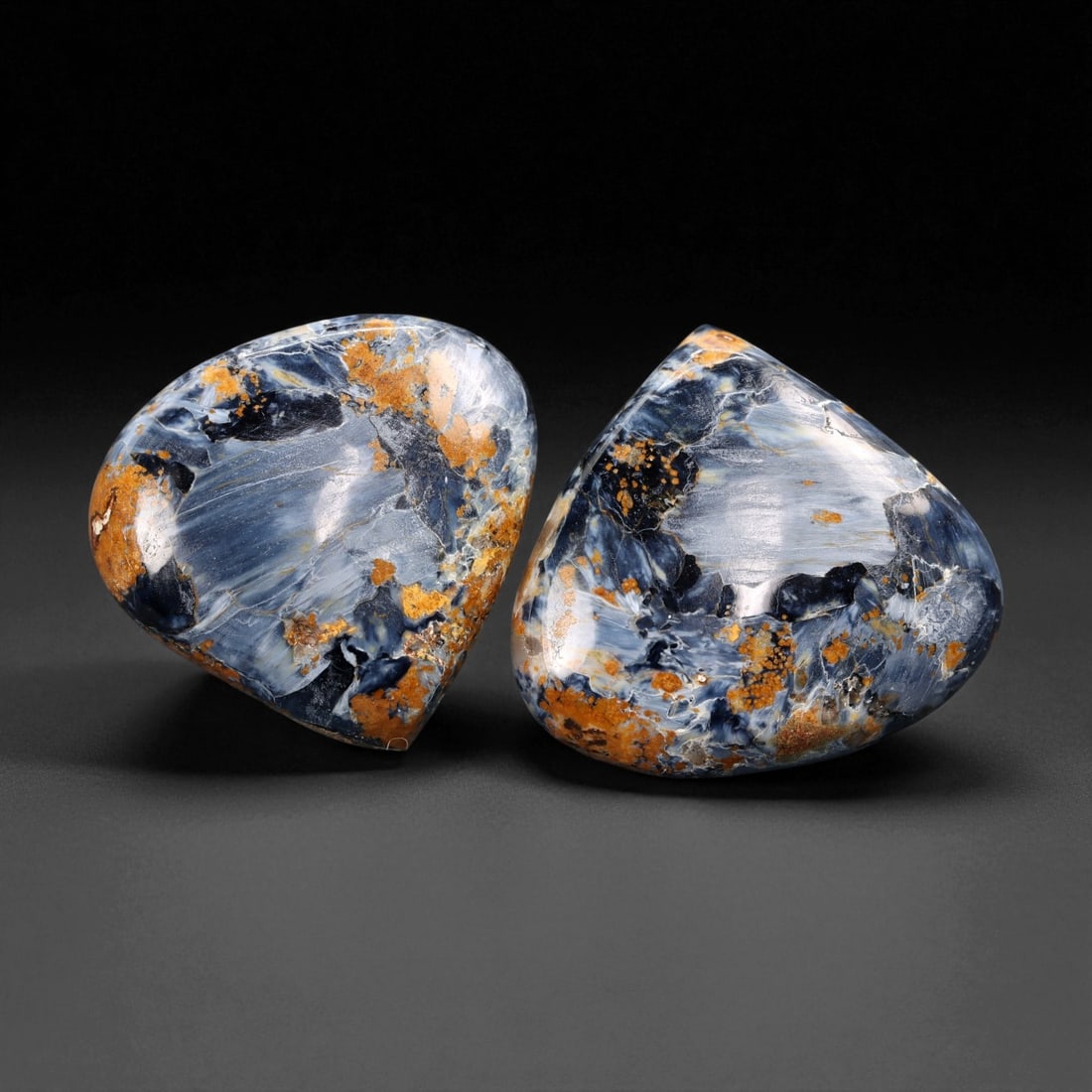 72.82 Carats Blue-Gold Pietersite Cabochon Pair - Natural Freeform Shields, 2.7 x 2.5 cm, 49XE: This dramatic pair of Pietersite cabochons delivers powerful visual energy with swirling flashes of deep stormy blue, icy silver, and warm golden ochre. The silky fibrous structure of the stone create