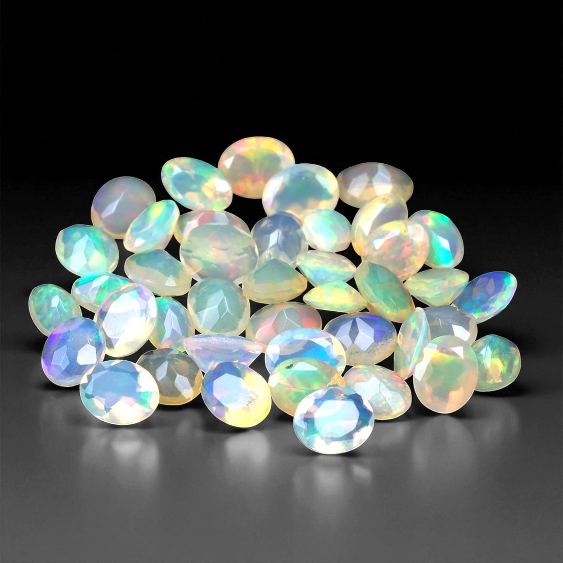 8.08 Carats Oval Cabochon Opal Parcel - Natural Welo Ethiopian Stones, 56XC: This mesmerizing parcel features 5x4 mm oval-cut opals, each glowing with exceptional play-of-color across a luminous, translucent body. Flashes of electric green, oceanic blue, and golden orange shif