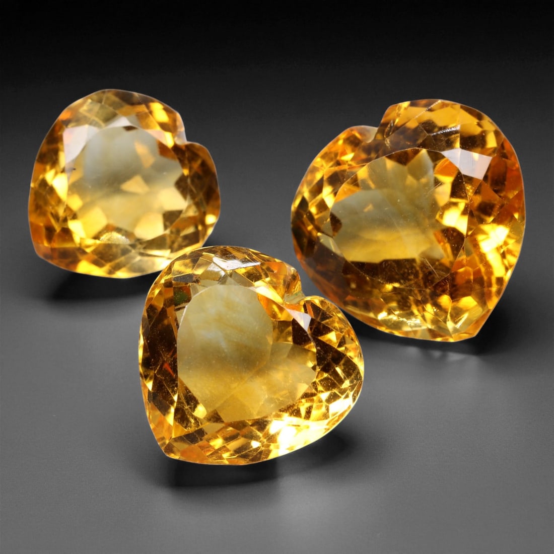 33.33 Carats Golden Yellow Citrine Heart Trio - Natural Brazilian Stones - 1.4 to 1.6 cm, 10XE: This enchanting trio of heart-shaped golden yellow citrine dazzles with warm, sunlit brilliance and precision faceting. Each gem displays a deep, golden hue with bright internal fire, creating a livel
