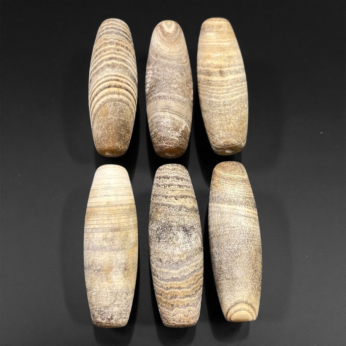 Ancient Medieval Tibetan Chung Dzi Agate Beads, c. 14th-16th Century CE, 3cm, 54EN: This harmonious group of Chung Dzi agate beads dates to the late medieval period of Tibet, approximately the 14th-16th century CE. Each bead exhibits natural banding in muted tones of cream, beige, an