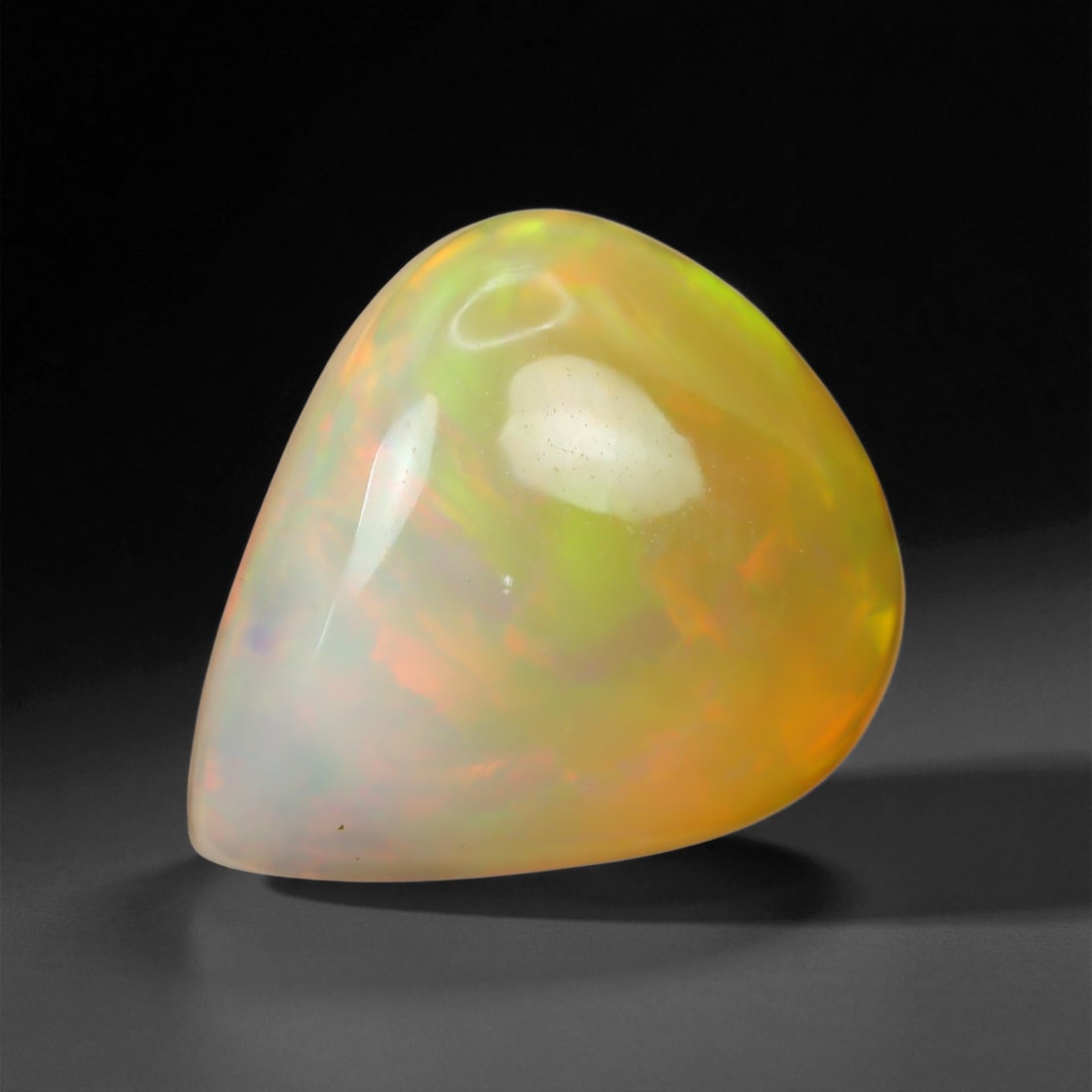6.57 Carats Pastel Neon Welo Opal Cabochon - Natural Ethiopian Gemstone, 84XE: This glowing Welo opal shimmers with delicate flashes of mint green, lavender, sky blue, and soft amber beneath a translucent, honey-toned body. Its internal light play is gentle yet vivid, with broad