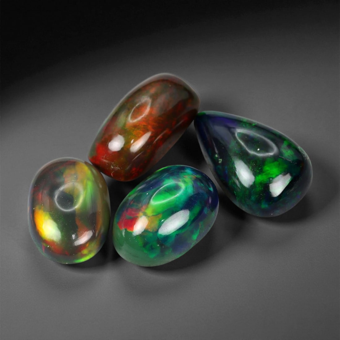 7.61 Carats Fiery Black Opal Selection - Natural Ethiopian Cabochons - 10 to 12 mm, 40XE: This dramatic selection of black opals captivates with intense flashes of crimson, emerald, and molten orange, all set against deep, inky body tones that amplify their internal fire. Each stone displa