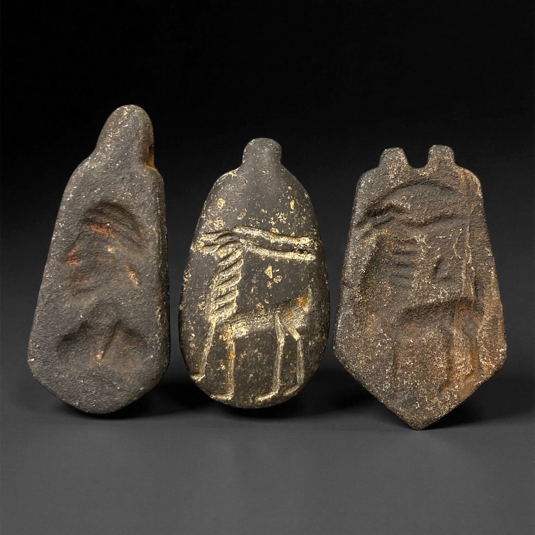 Ancient Neo-Assyrian Steatite Amulet Group, c. 8th-7th Century BCE, 4-4.5cm, 94EK: This rare assemblage of three carved steatite amulets originates from the Neo-Assyrian period, a pinnacle of Mesopotamian artistry renowned for its intricate symbolism and protective talismans. Each p
