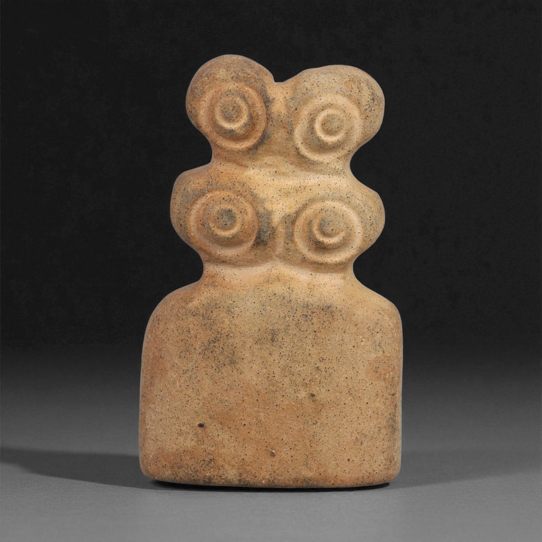 A Near Eastern Stone Double-Tiered Eye Idol, 4th-3rd Millennium BCE, 22ZA: Carved from a light brown stone with fine dark inclusions, the figure is shaped with a double-tiered head, each level bearing a pair of recessed circular eyes defined by concentric grooves. The should