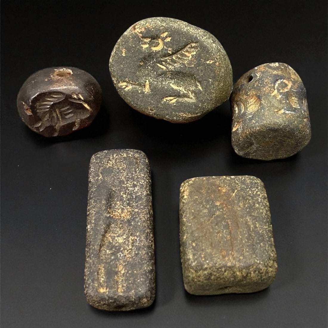 Ancient Akkadian Hematite and Steatite Stamp Seals, c. 23rd-21st Century BCE, 1.2-1.7 cm, 26EK: This elegant group of five miniature stamp seals originates from the Akkadian period, a pivotal era in Mesopotamian history renowned for its artistry and centralized governance. Carved from hematite a