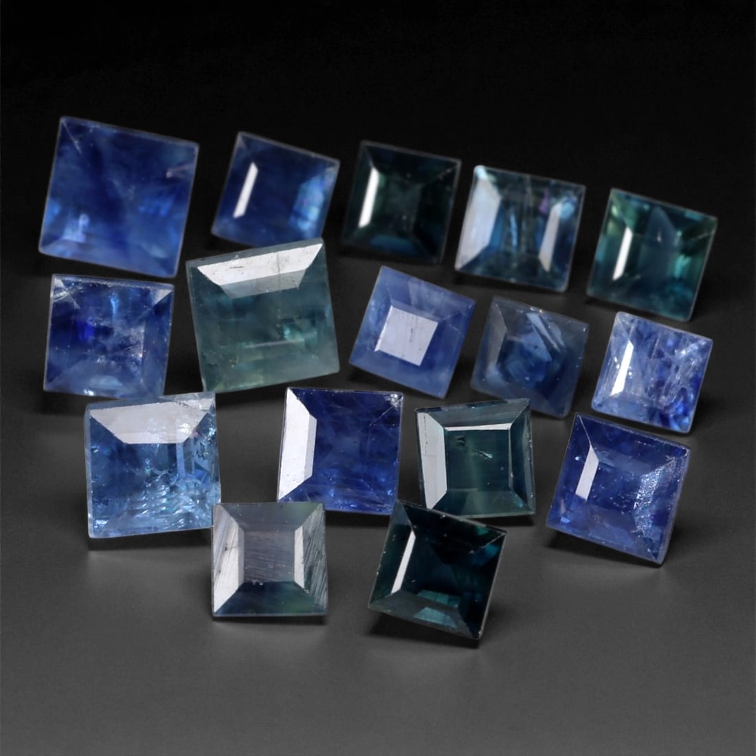 3.98 Carats Mixed Blue Sapphire Princess Parcel - Natural Loose Gemstones, 32XB: This intricate parcel features 16 square-cut sapphires, each ranging between 2 and 3 mm. Displaying a refined spectrum from icy denim to deep teal and inky navy, these stones offer a subtle interplay