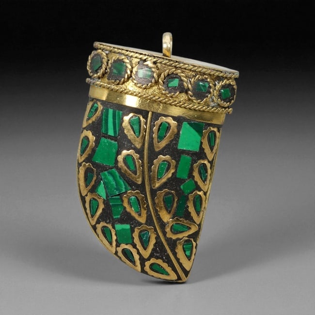 Himalayan Gilt Metal and Malachite Pendant, 20th Century, 83XD: Formed in gilt metal over a dark ground, the pendant is shaped with a curved, tapering body and a flat upper rim fitted with a suspension loop. The surface is inlaid with irregular malachite plaques s