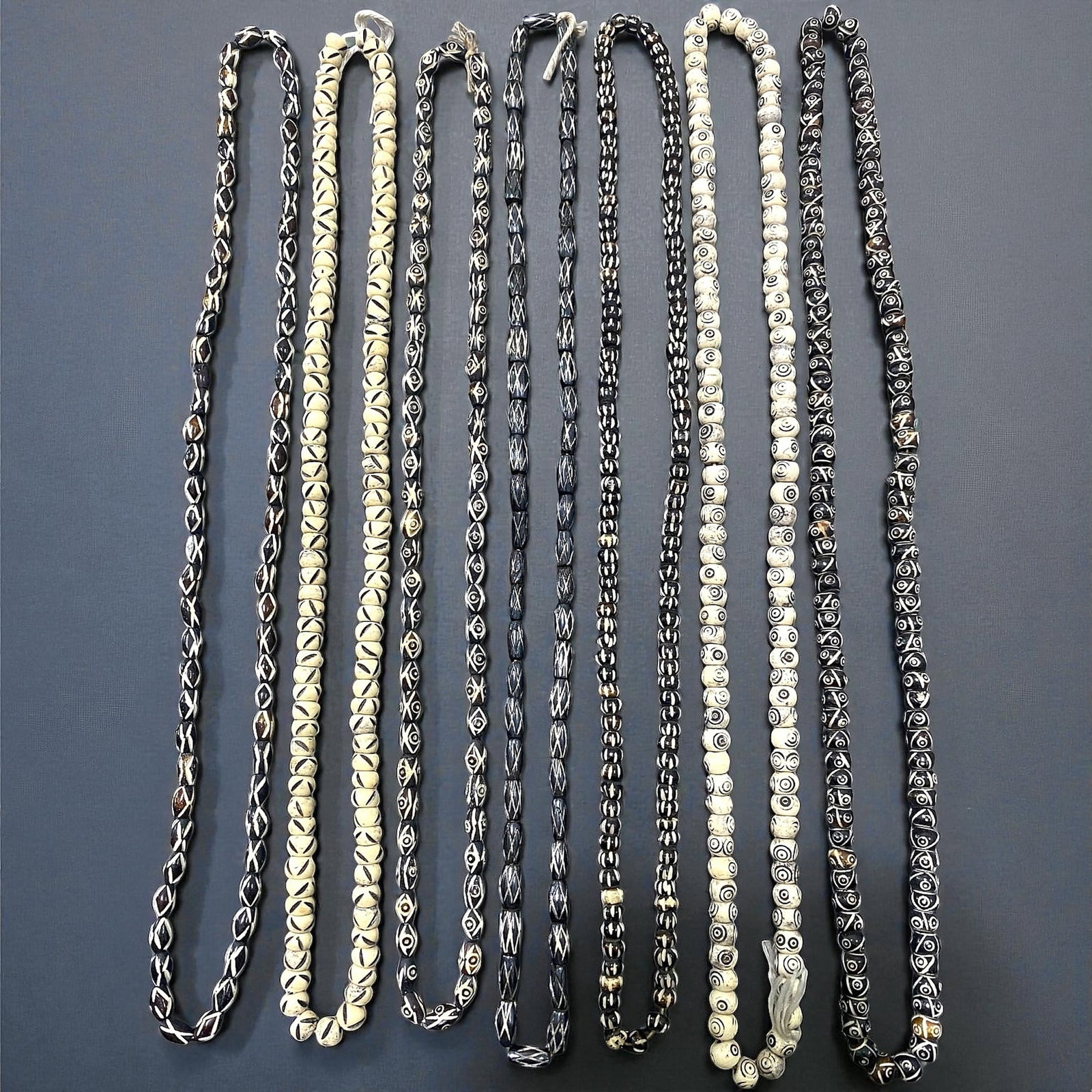 Vintage Himalayan Etched Bone Prayer Bead Strands, c. 20th Century, 7 Strands, 55EX: This collection of seven vintage Himalayan bead strands embodies the expressive carving traditions of Nepalese and Tibetan artisans during the 20th century. Each strand features hand-worked bone beads