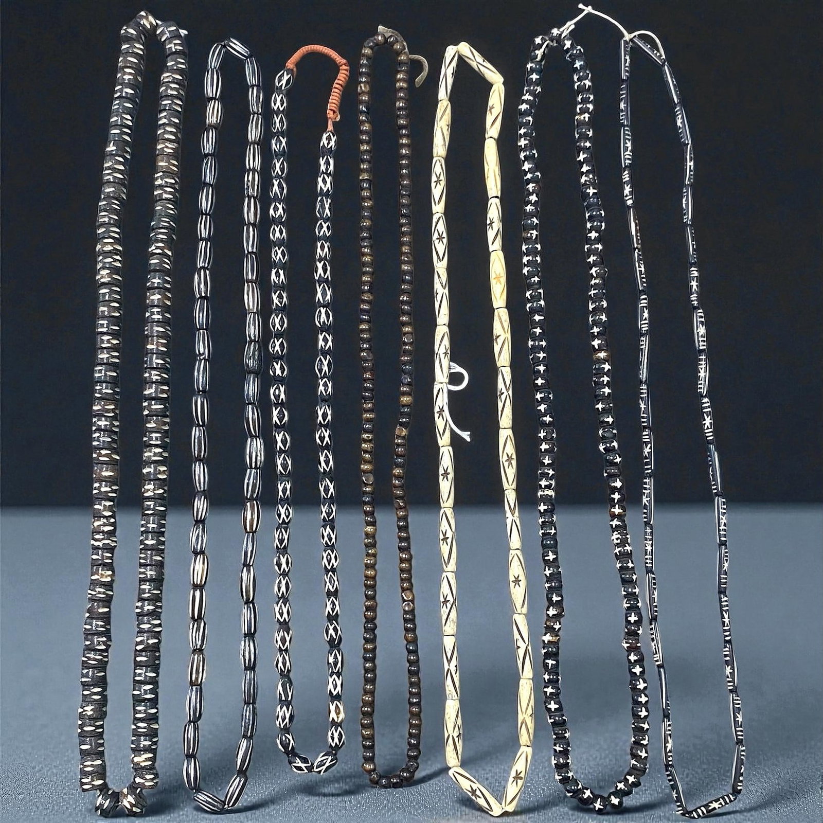 Vintage Himalayan Etched Bone and Wood Prayer Bead Strands, c. 20th Century, 7 Strands, 80EX: This set of seven vintage Himalayan bead strands captures the enduring devotional artistry practiced across Nepal and Tibet during the 20th century. Crafted from hand-carved bone and dark-toned hardwo