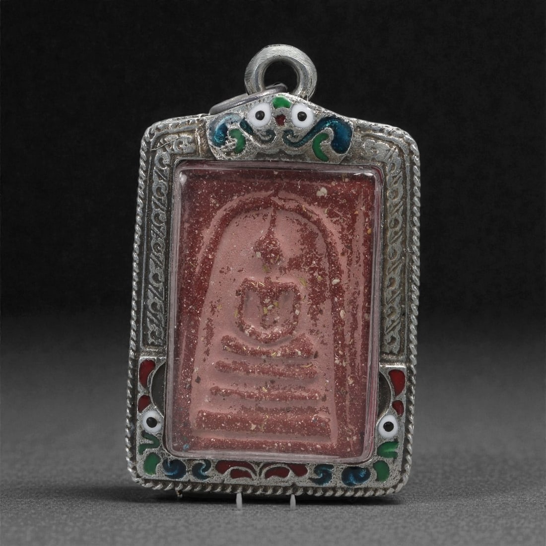Buddhist Clay Amulet - Enshrined Buddha Pendant, 63C: Formed in pressed reddish clay, this amulet bears a recessed image of a seated Buddha placed beneath an arched niche, with horizontal base lines indicating the tiered platform. The surface retains nat