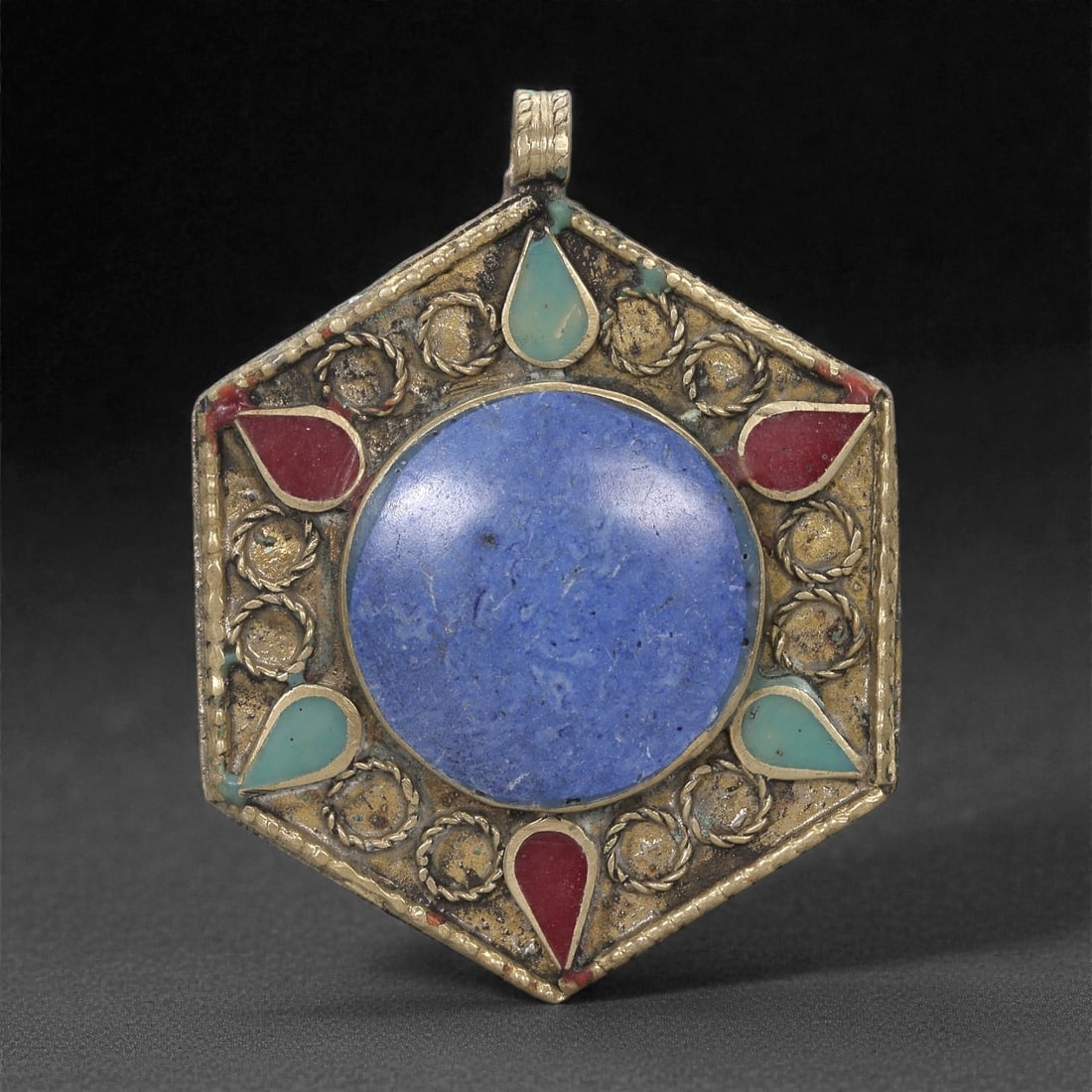 Himalayan Style Brass Pendant - Lapis Turquoise Coral Hexagonal, 42XF: This hexagonal brass pendant centers on a large circular lapis inlay whose smooth surface displays natural tonal variation. Surrounding the central field is a ring of raised circular metal elements, e