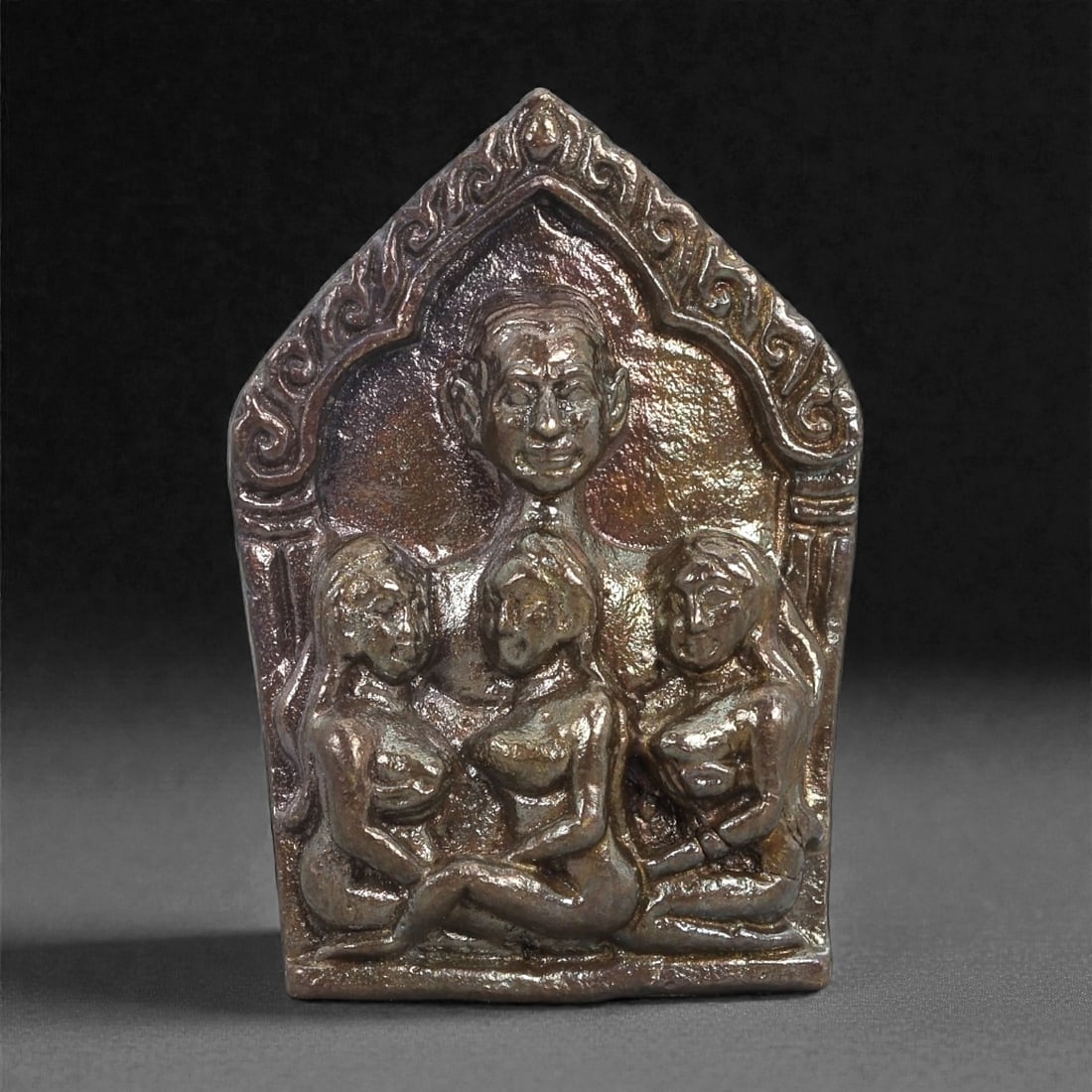 Bronze Erotic Panel - Southeast Asian Ritual Figurine, 3D: Cast in bronze with a reflective, warm-toned surface, this small panel depicts a central male figure above three seated female figures arranged in a symmetrical composition. The bodies are modeled wit