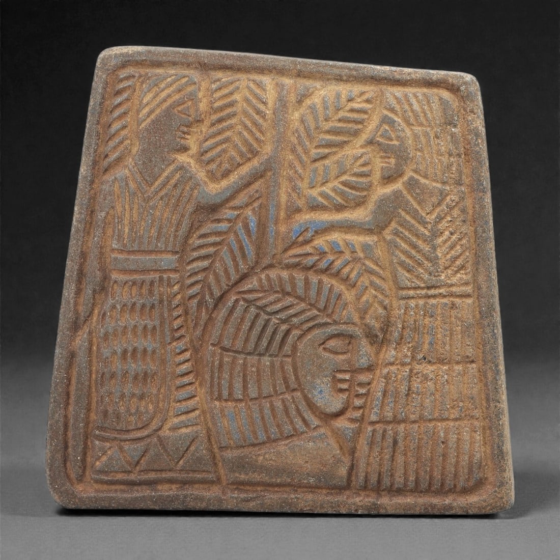 A Sasanian Lapis Lazuli Relief Plaque, 3rd-7th Century CE, 8cm, 60LQ: Carved from lapis lazuli with brown archaeological surface accretions, the plaque is worked in shallow relief exhibiting the characteristic linear incision and patterned surface treatment associated w