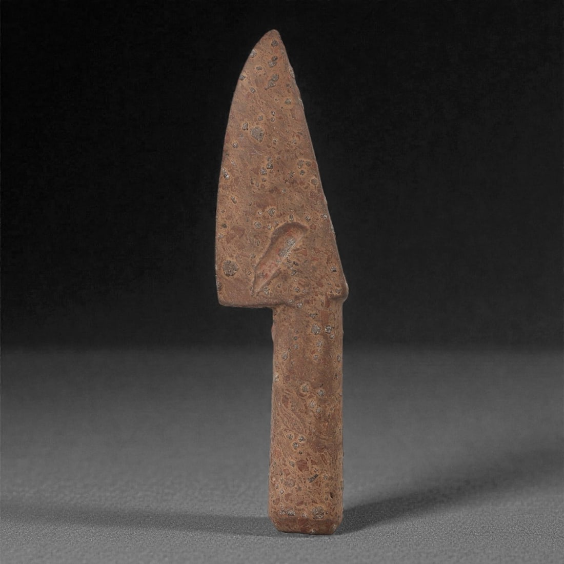 A Sino-Mongolian Fossil Jasper Ritual Knife, 2nd-1st Millennium BCE, 7LR: Carved from dense fossiliferous jasper, the object is shaped as a narrow, tapering blade with a straight handle section and a slight angular transition defined by a shallow lateral notch. The surfaces