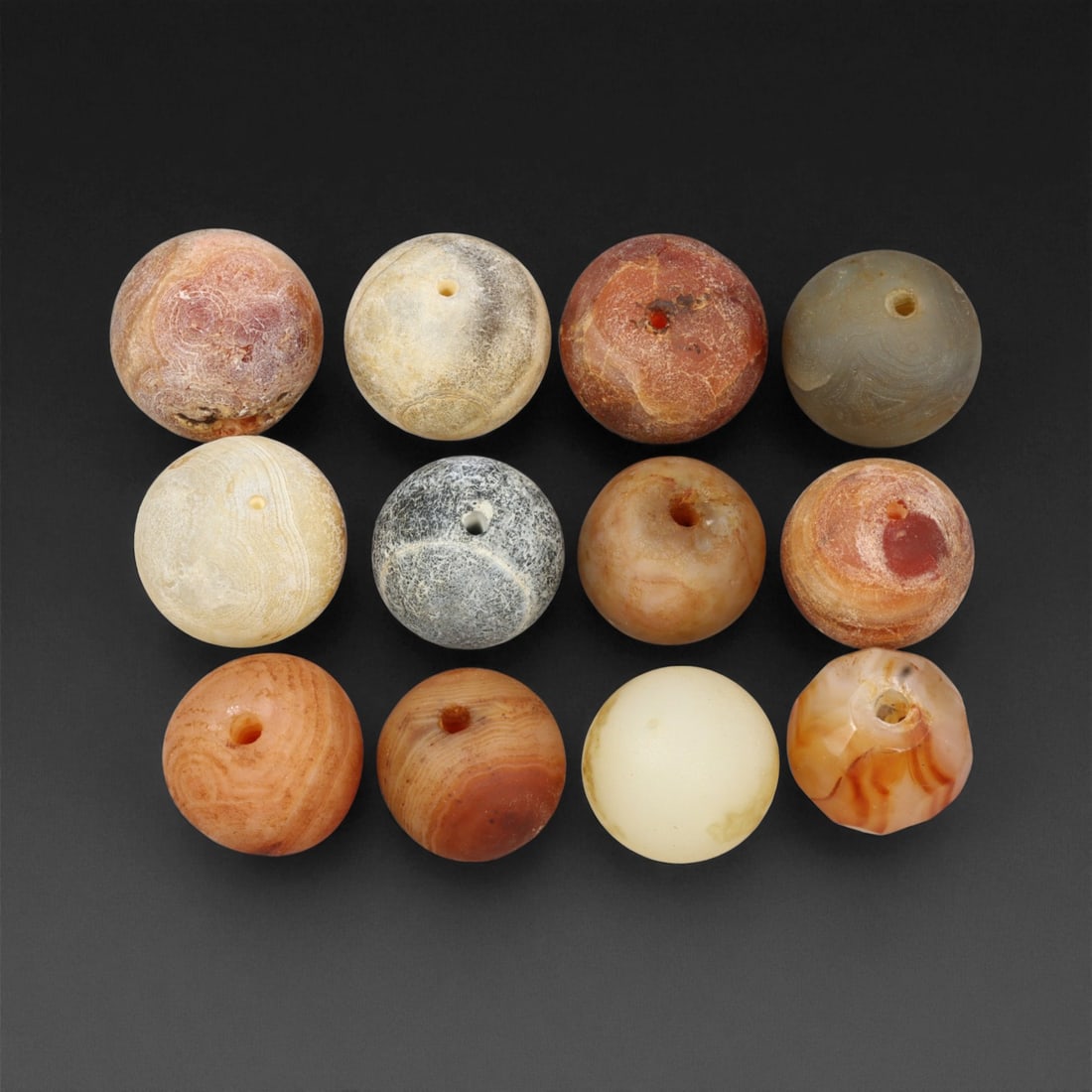 Antique Tibetan Agate and Chalcedony Prayer Beads Collection, c. 18th-19th Century, 1.5-1.7 cm, 66EM: This graceful assemblage of antique Tibetan beads, carved from agate and chalcedony, dates to the 18th-19th century and embodies the quiet spiritual refinement of Himalayan craftsmanship. Each bead is