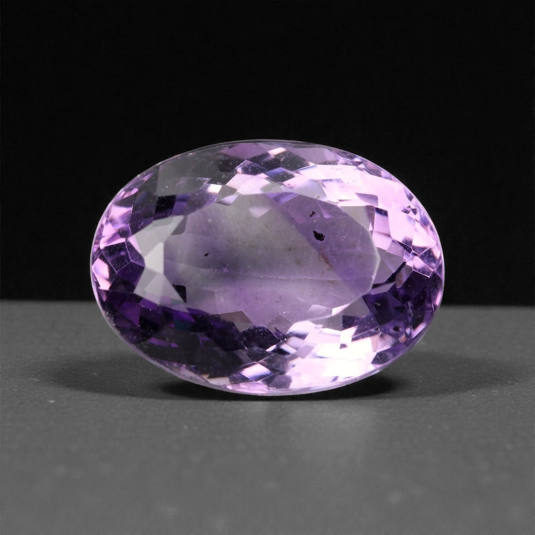 18.16 Carats Light Purple Amethyst Oval - Natural Brazilian Stone - 19.6x14.4mm, 79XA: This generously sized amethyst glows with a soft lavender-to-light purple hue, creating an ethereal presence in its elongated oval cut. The stone displays excellent brilliance through its precise face