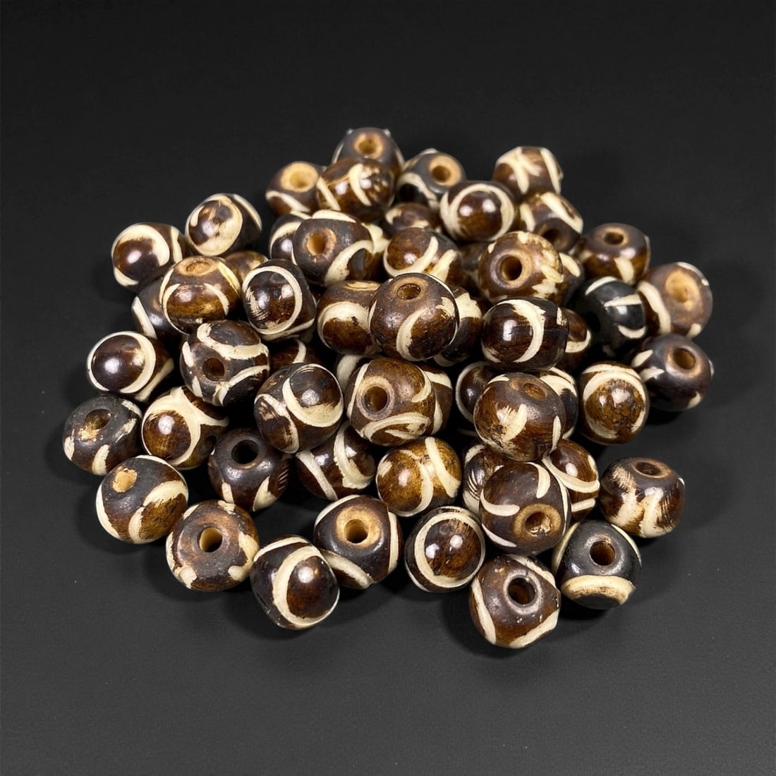Mid-20th Century Tibetan Hand-Carved Wood Beads, 0.8cm, 87EP: A collection of Tibetan wood beads, each individually carved and polished, showcasing the natural beauty of the dark-stained grain with contrasting pale surface decoration. These mid-century examples 