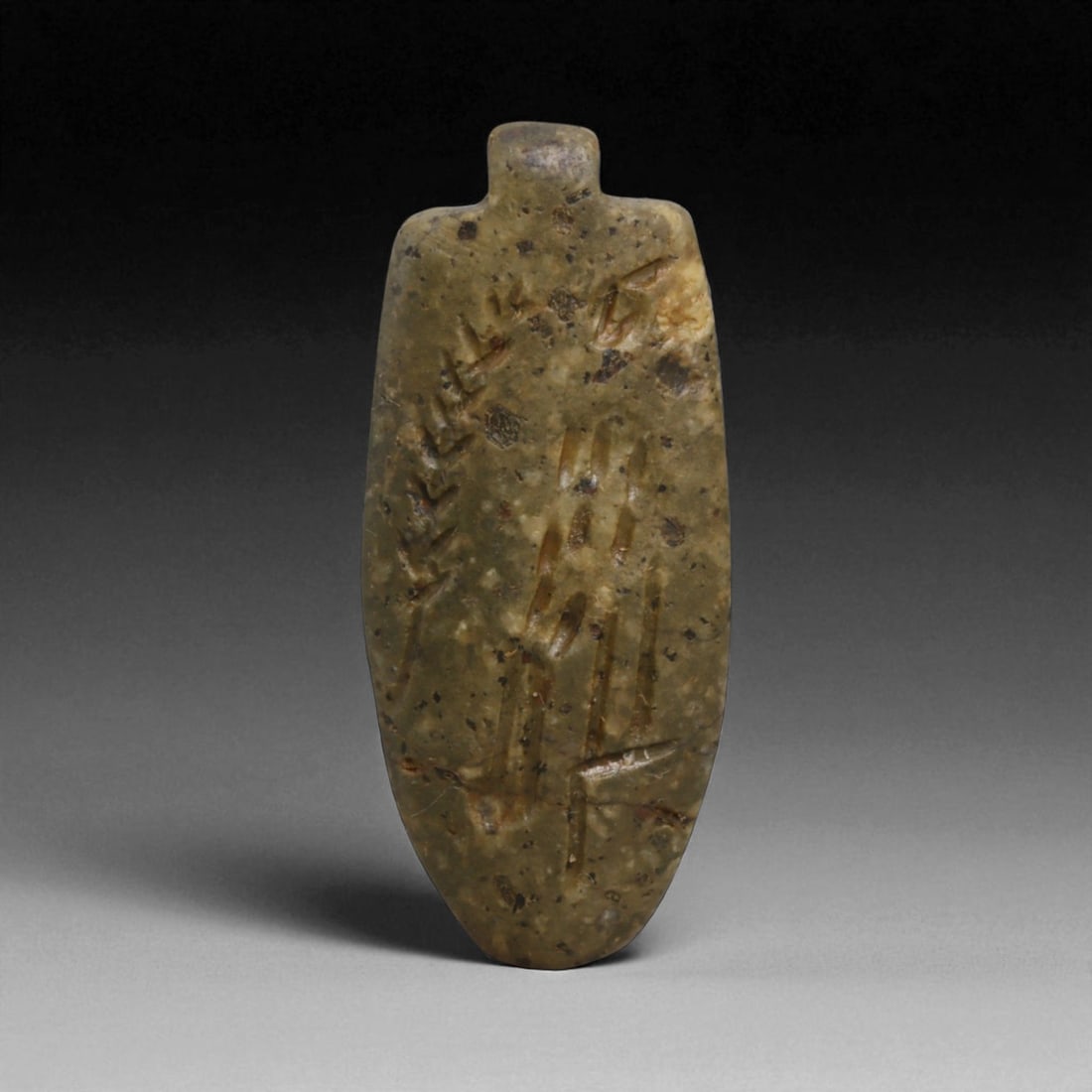 A Neo-Babylonian Steatite Gazelle Motif Amulet Pendant, c. 7th-6th Century BCE, 4.7cm, 10g, 10LH: This pendant, carved from dark steatite, dates to the Neo-Babylonian period, c. 7th-6th century BCE. Pierced at the top for suspension, it was designed as a personal amulet to be worn close to the bod