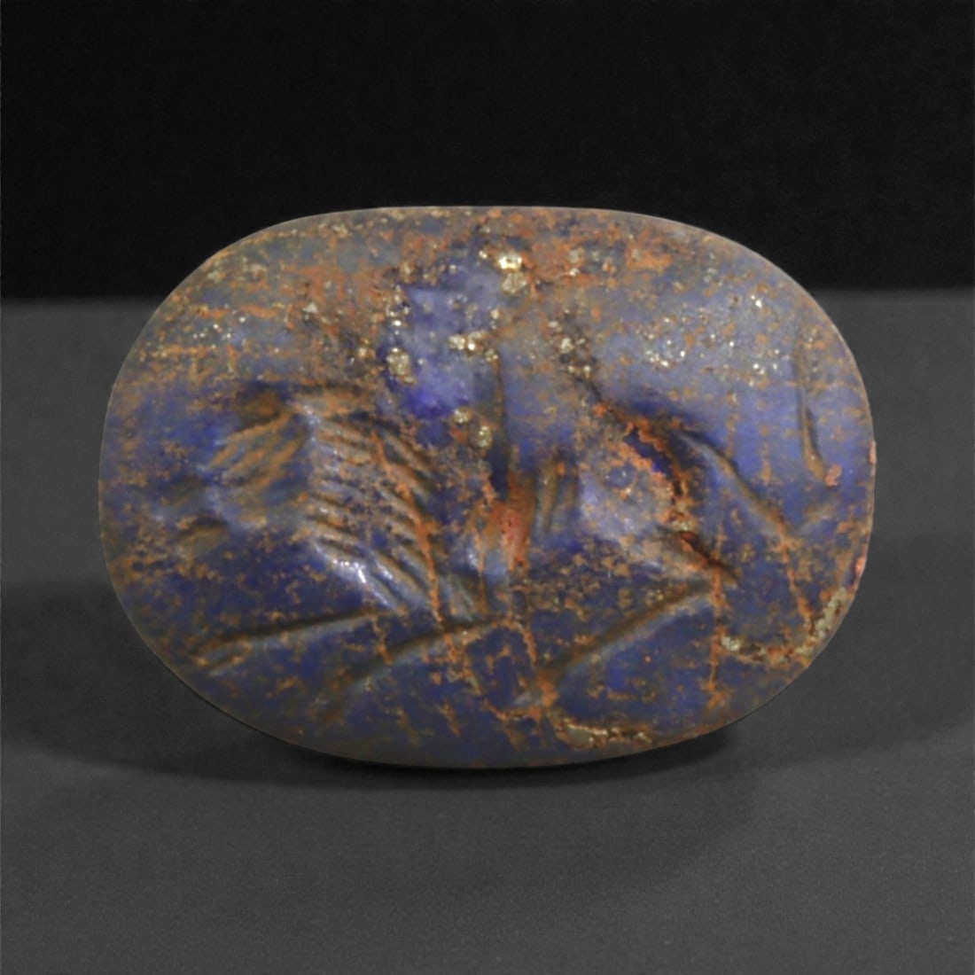 A Neo-Assyrian Lapis Lazuli Intaglio Depicting a Galloping Horse, c. 9th-7th Century BCE, 2cm, 31BE: This finely engraved lapis lazuli intaglio, dating to the Neo-Assyrian Empire (c. 900-700 BCE), exemplifies the precision and elegance of Mesopotamian glyptic art during the height of imperial expansi