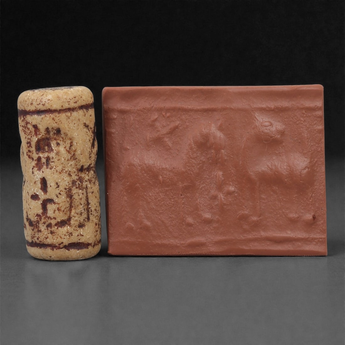 A Near Eastern Stone Cylinder Seal, 3rd Millennium BCE, 3.5cm, 8LP: Carved from stone with darker surface mottling, the cylindrical seal bears a continuous engraved scene. The carving is executed in shallow linear grooves typical of Early Bronze Age glyptic traditions