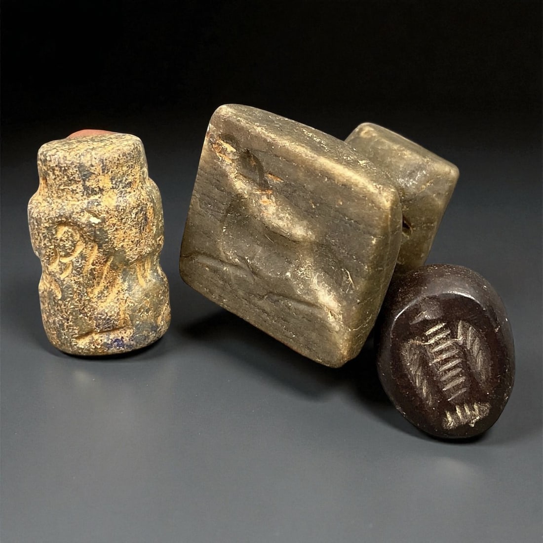 Ancient Neo-Sumerian Steatite and Hematite Seal Group, c. 21st-20th Century BCE, 1.2-2.5cm, 94EP: This refined trio of ancient seals, carved from steatite and hematite, dates to the Neo-Sumerian period, a flourishing age of artistic and administrative sophistication in early Mesopotamia. Each seal