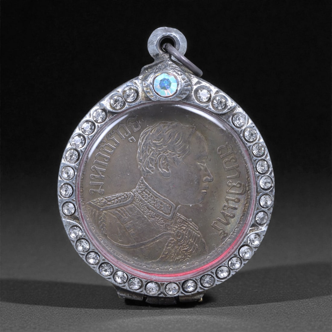 Framed Coin Amulet Pendant - Southeast Asian Royal and Elephant Motif, 44L: This circular pendant houses a coin featuring a portrait bust on one side and an elephant emblem on the reverse, both protected beneath a clear cover and set within a later metal frame ornamented with