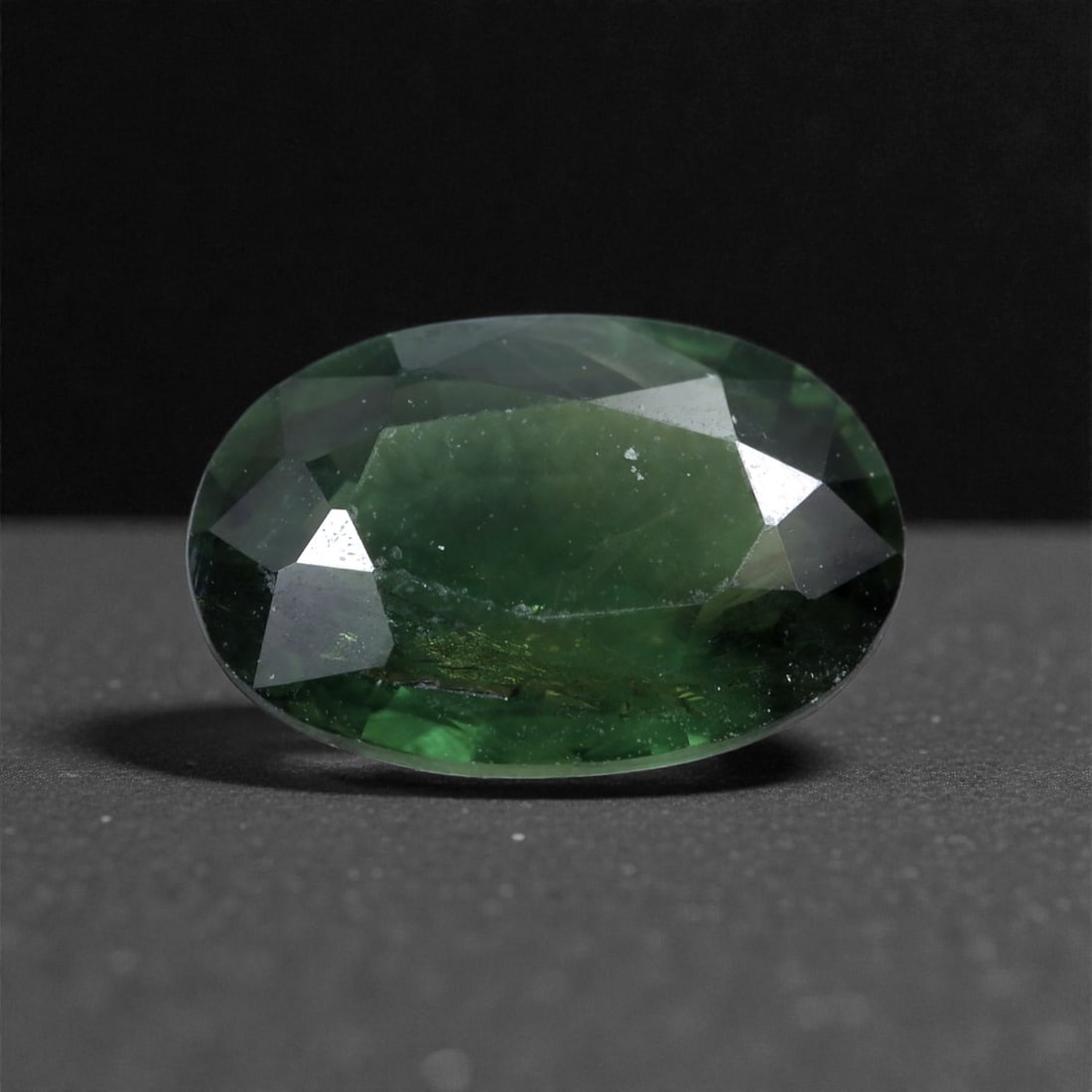 1.46 Carats Forest Green Sapphire - Natural Madagascan Gem 8x5mm, 9XC: This richly toned sapphire reveals a deep forest green hue with subtle teal undertones, evoking the lush shadows of dense foliage. Weighing 1.46 carats and measuring 8x5 mm, the gem is cut to capture 